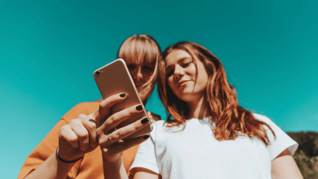 Mutter und Tochter schauen gemeinsam auf ein Smartphone