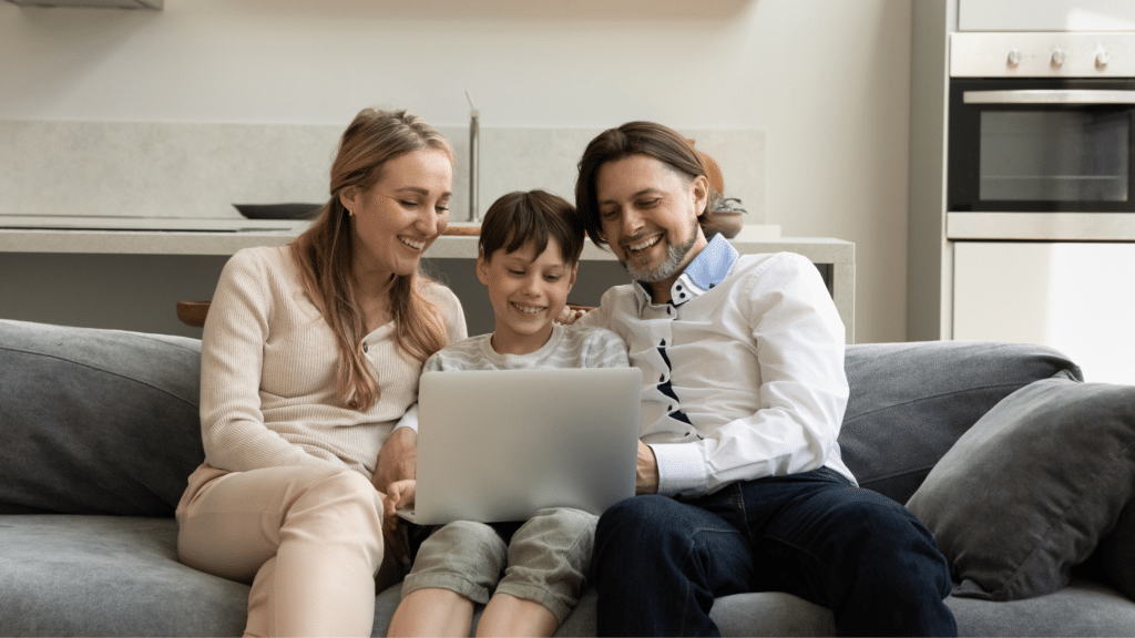 Familie nutzt gemeinsam digitale Medien auf dem Sofa